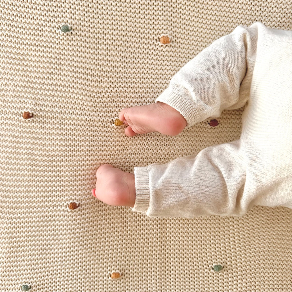 Die cremefarbene Strickdecke