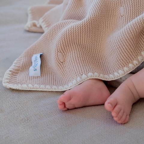 Die cremefarbene Strickdecke