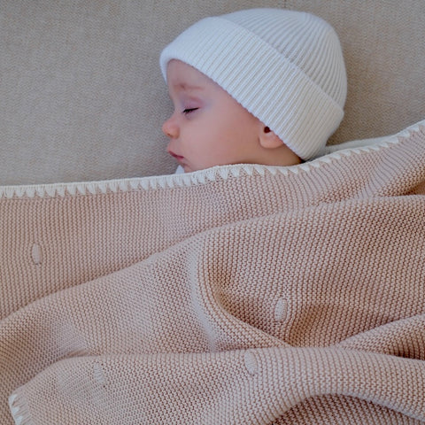 Die cremefarbene Strickdecke