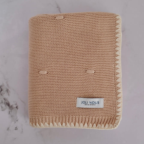 Die cremefarbene Strickdecke